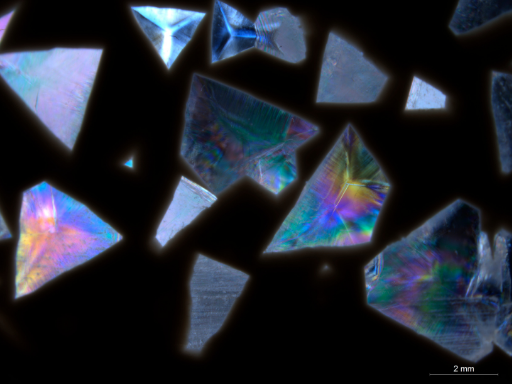 Sommets pyramidaux de quartz enchâssés dans de la calcédoine beige vus en lumière transmise polarisée (polariseurs croisés)