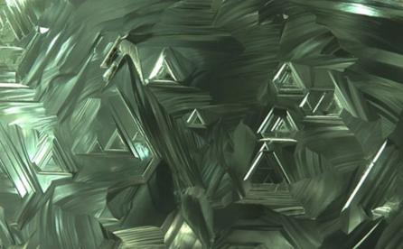Trigons on the surface of a green diamond crystal.
